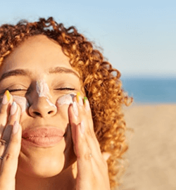 Chica deslumbrada por el sol y mirando a cámara